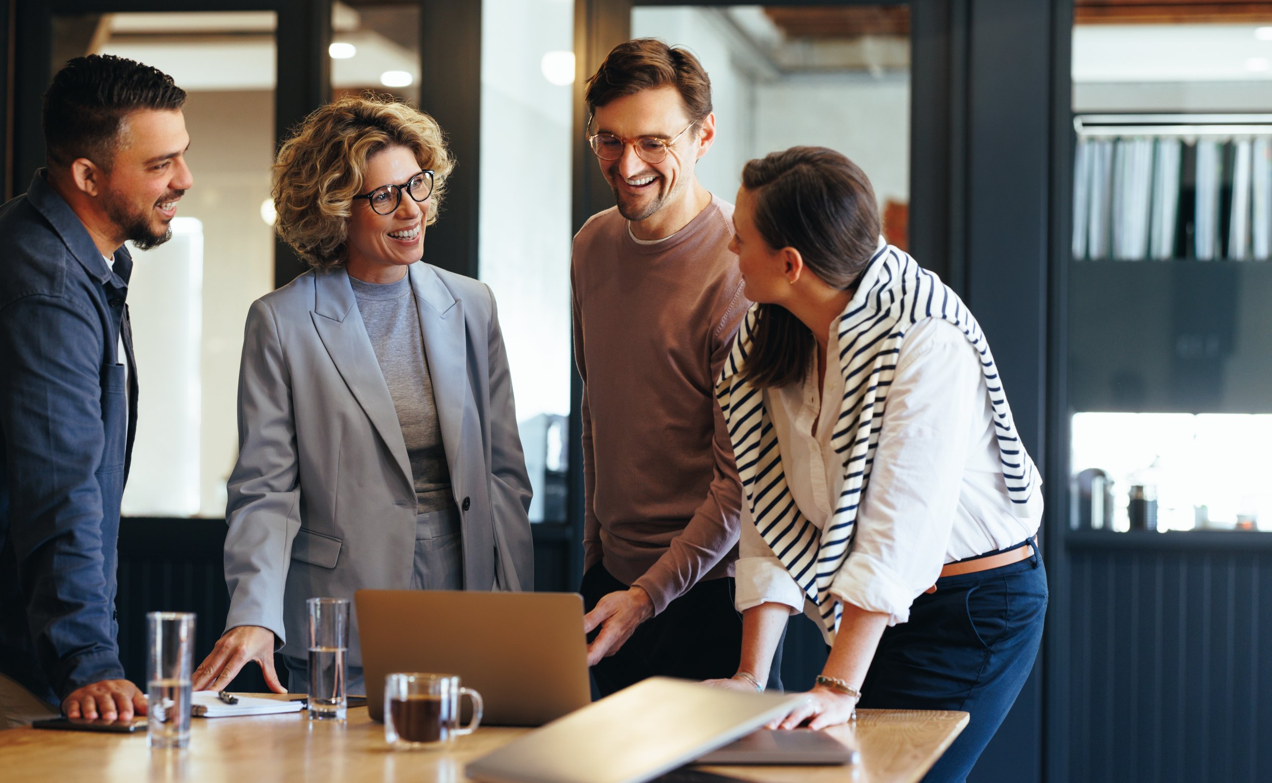 People in a meeting room around a laptop